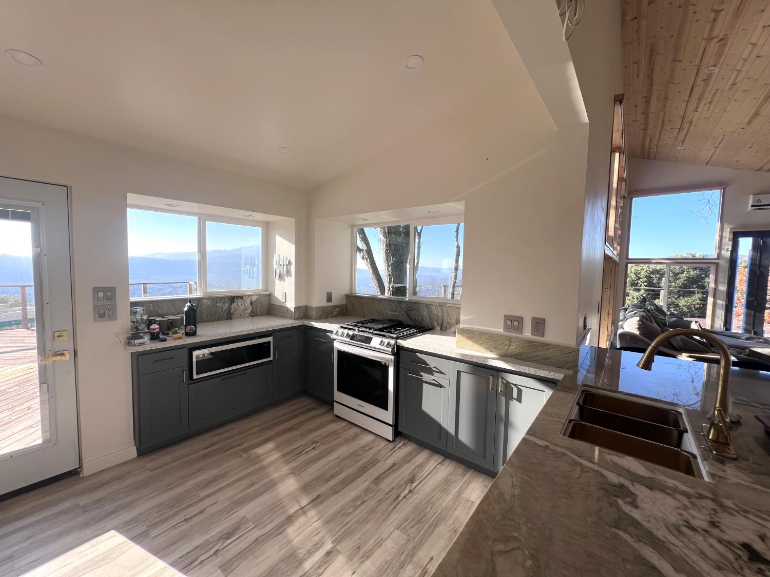 51571 Coyote Ridge Road Oakhurst, CA 93644 - Photo 11 of 81 a large kitchen with stainless steel appliances granite countertop a stove and a refrigerator