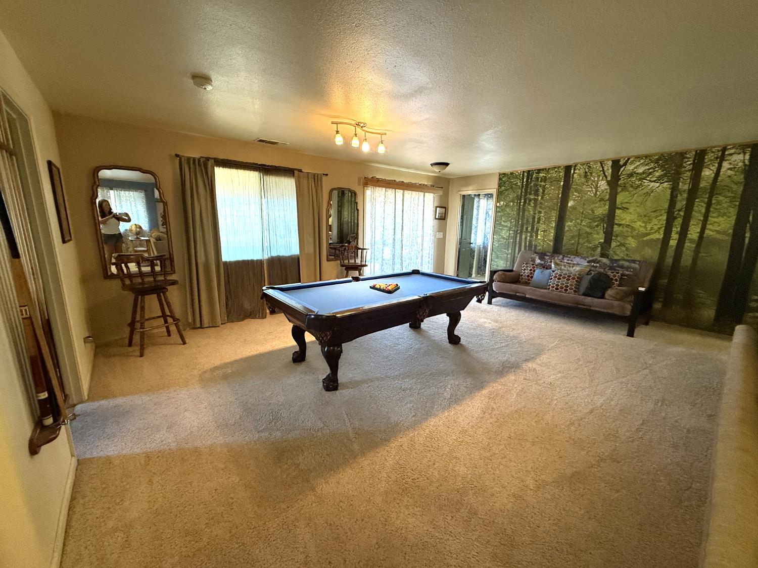 51571 Coyote Ridge Road Oakhurst, CA 93644 - Photo 42 of 81 a living room with furniture pool table and large windows