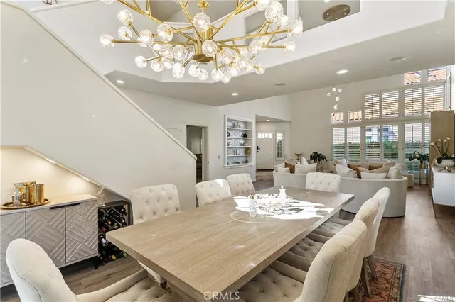 a view of a dining room with furniture a chandelier and wooden floor