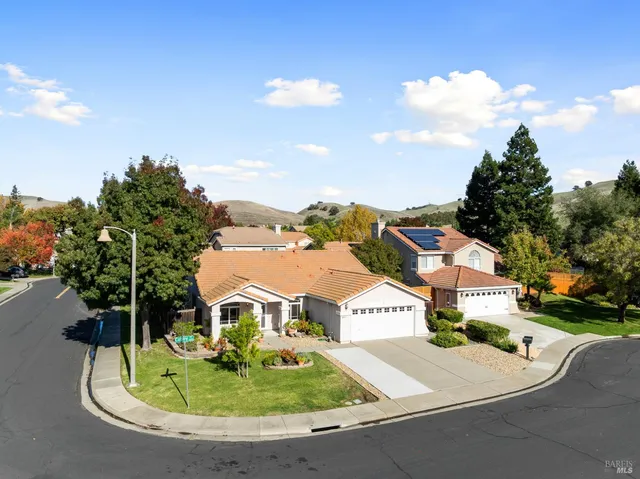 an aerial view of residential houses with outdoor space and trees