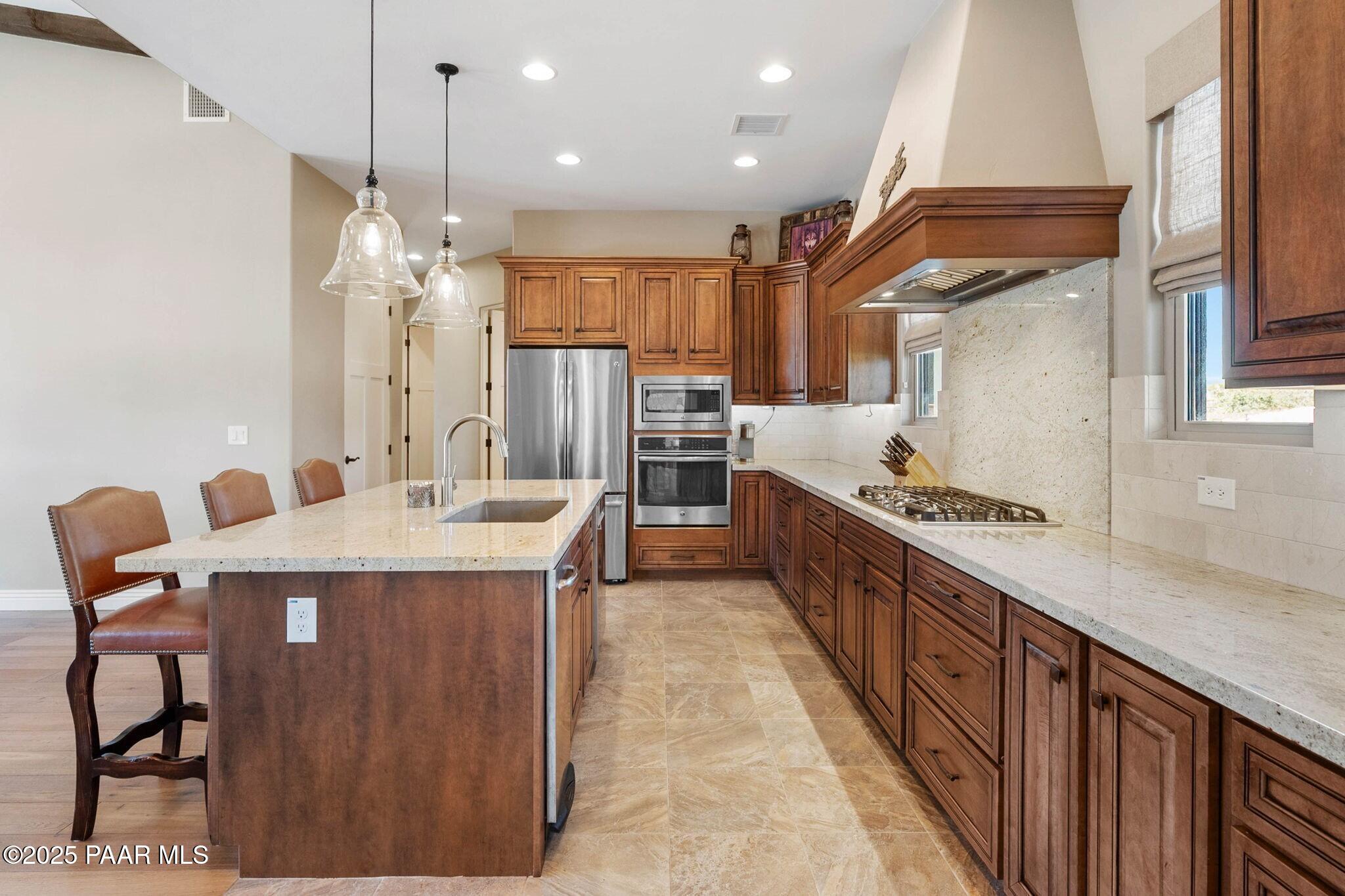 9309 North Callahan Road Prescott, AZ 86305 - Photo 14 of 55 a kitchen with a table chairs stove and refrigerator