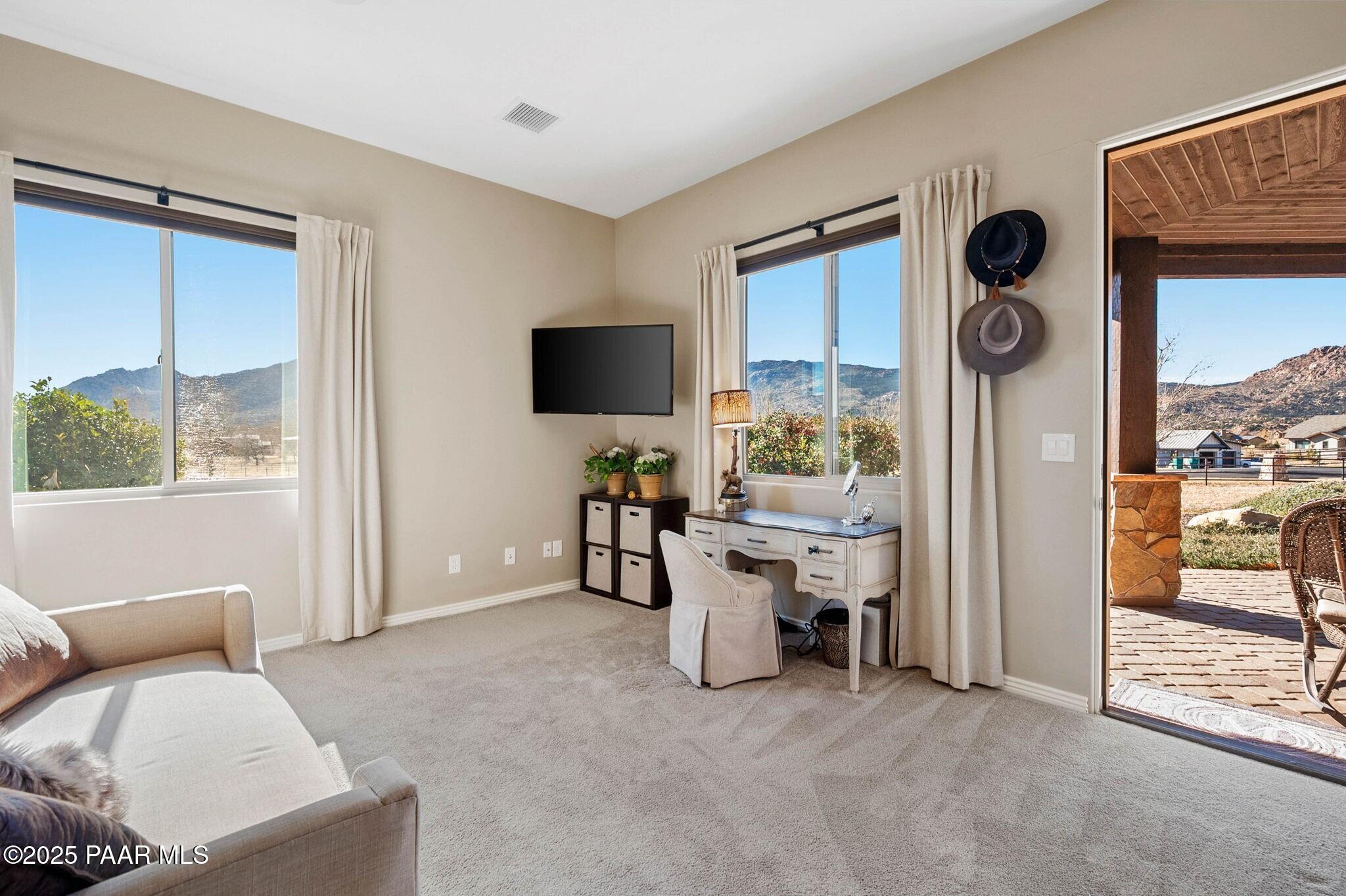 9309 North Callahan Road Prescott, AZ 86305 - Photo 17 of 55 a living room with furniture a floor to ceiling window and a flat screen tv