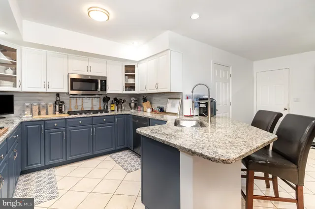 a kitchen with a stove a sink a microwave a dining table and chairs