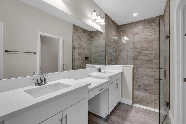 a bathroom with a double vanity sink mirror and shower