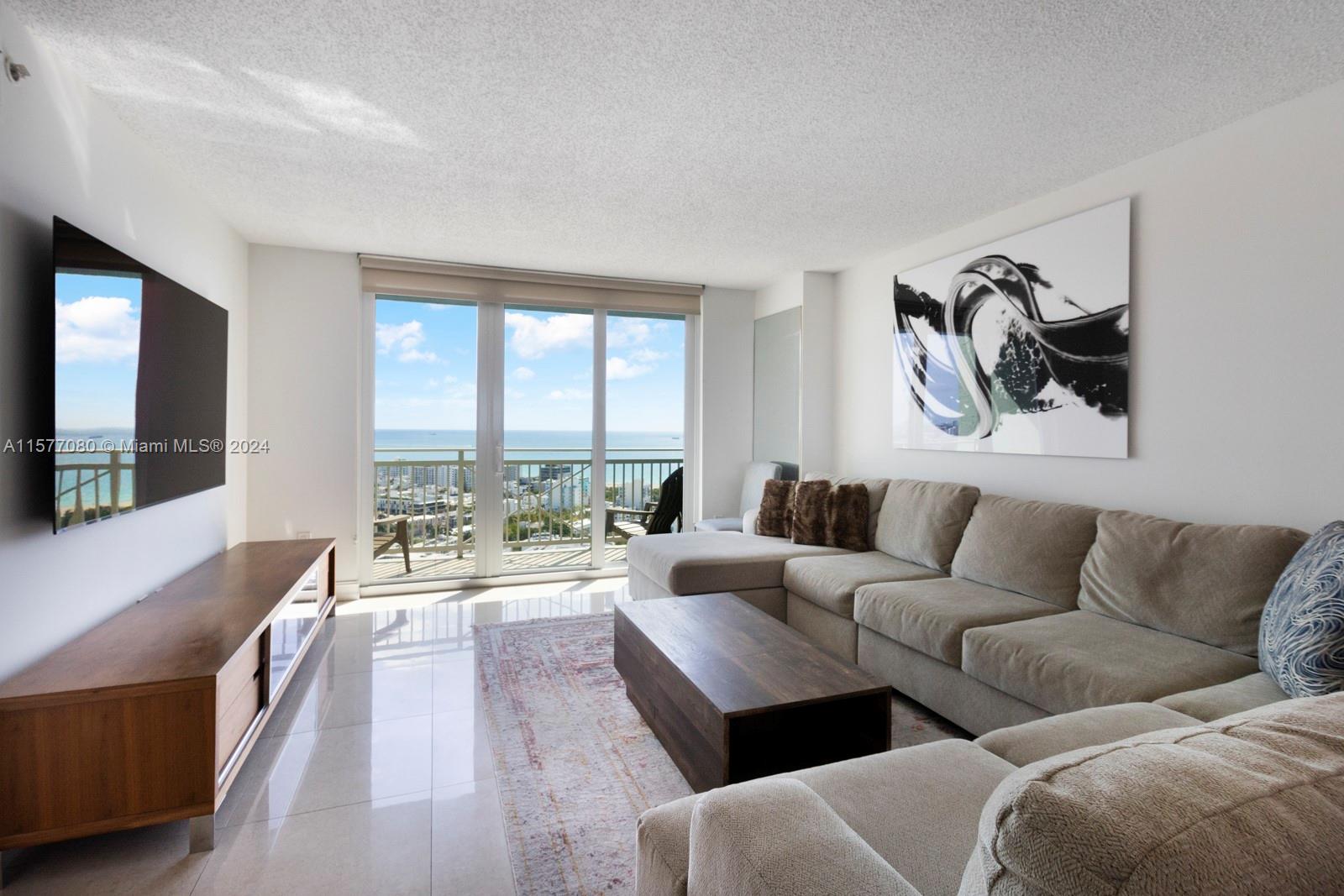 90 Alton Road, Unit 2907 Miami Beach, FL 33139 - Photo 2 of 18 a living room with furniture and a large window