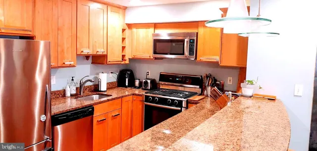 a kitchen with stainless steel appliances a stove sink microwave and refrigerator