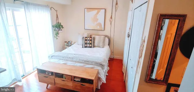 a bedroom with a bed and wooden floor