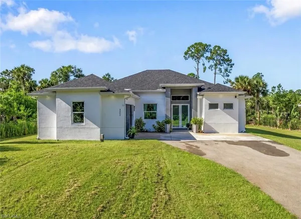 a front view of a house with a garden and yard