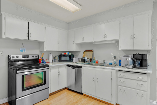 1275 North Geneva Road Provo, UT 84601 - Photo 5 of 25 Kitchen featuring white cabinetry with silver hardware, white countertops, stainless steel range, and wood-finish flooring