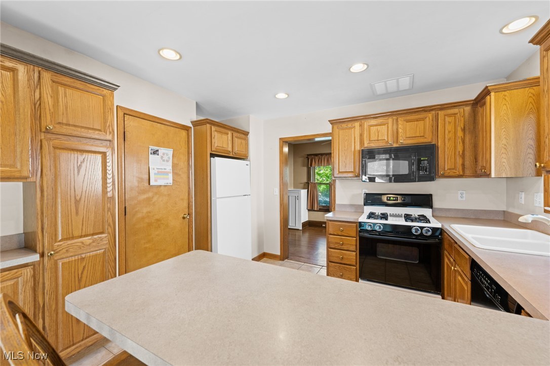 3918 Bluestone Road Cleveland Heights, OH 44121 - Photo 8 of 27 Kitchen featuring a kitchen bar, sink, and black appliances