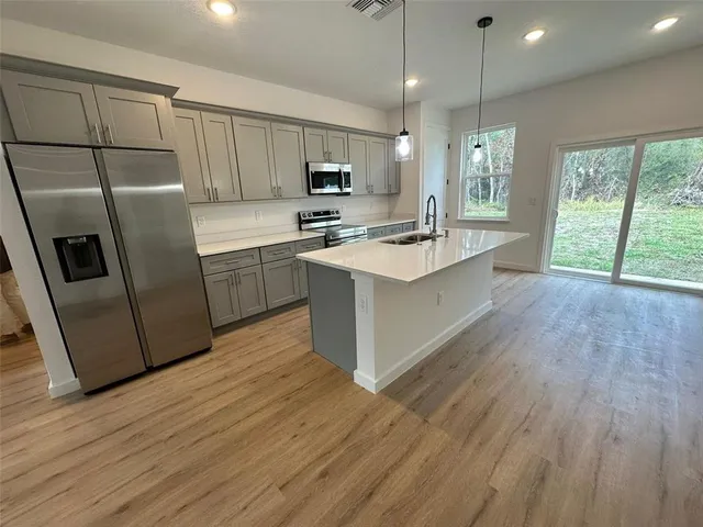a kitchen with refrigerator cabinets and wooden floor