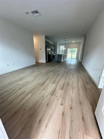 a view of empty room with wooden floor