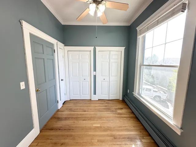 a view of a hallway with window and wooden floor