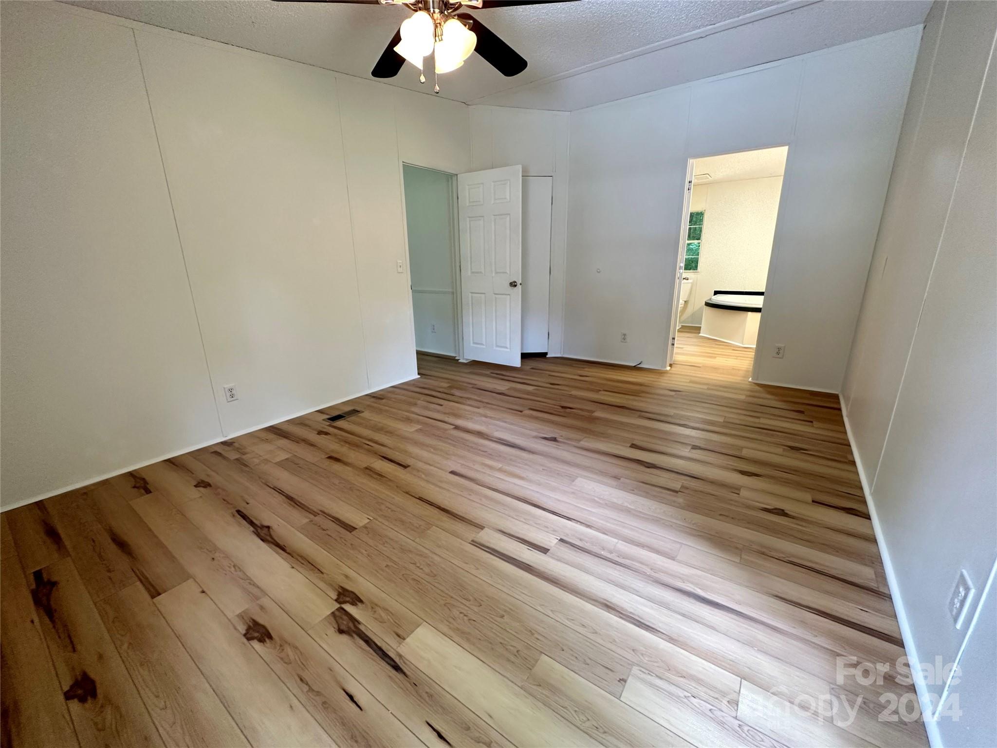 6686 Old Plank Road Stanley, NC 28164 - Photo 11 of 17 a view of empty room with wooden floor and fan