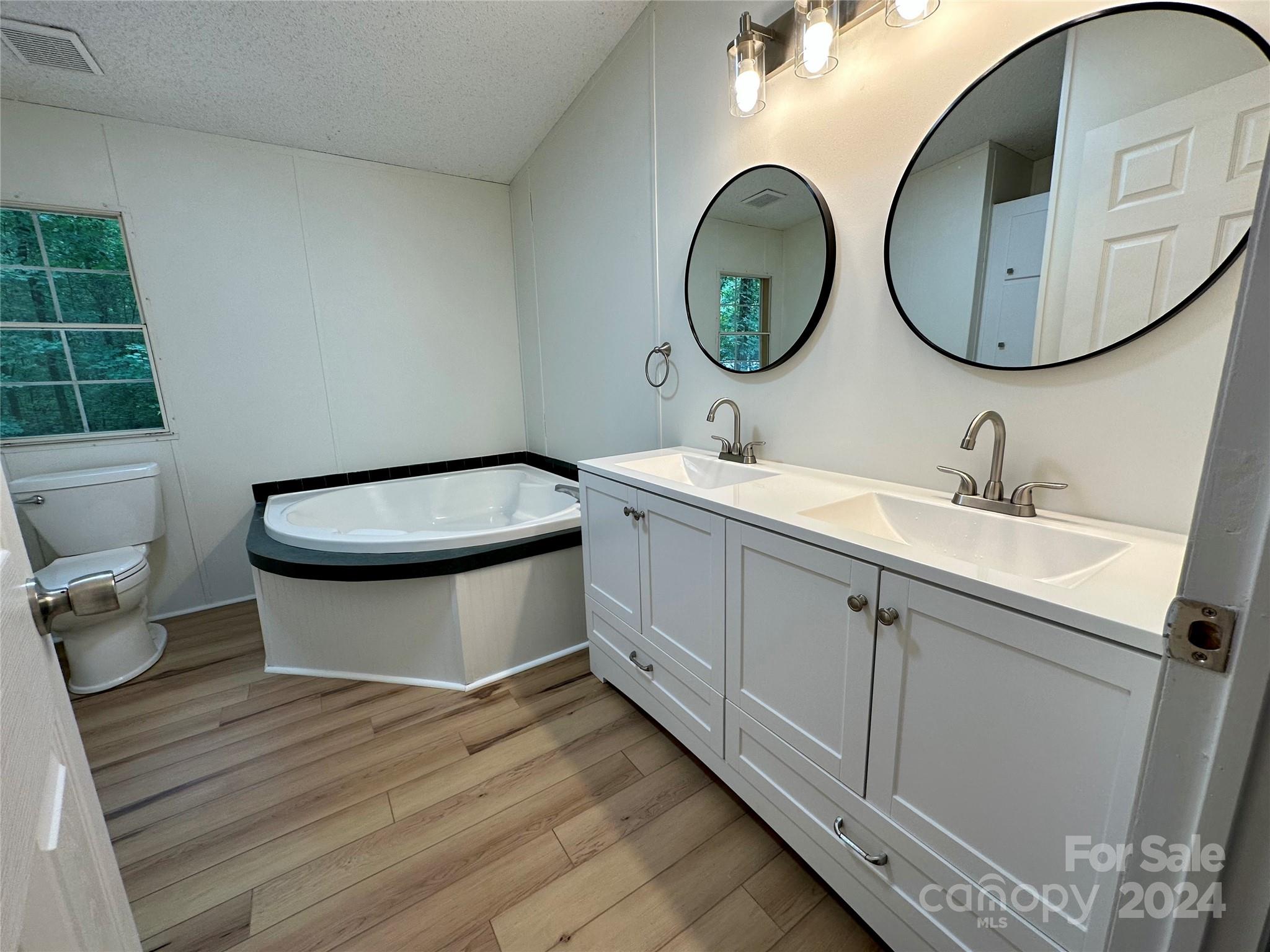 6686 Old Plank Road Stanley, NC 28164 - Photo 12 of 17 a bathroom with a toilet sink and mirror