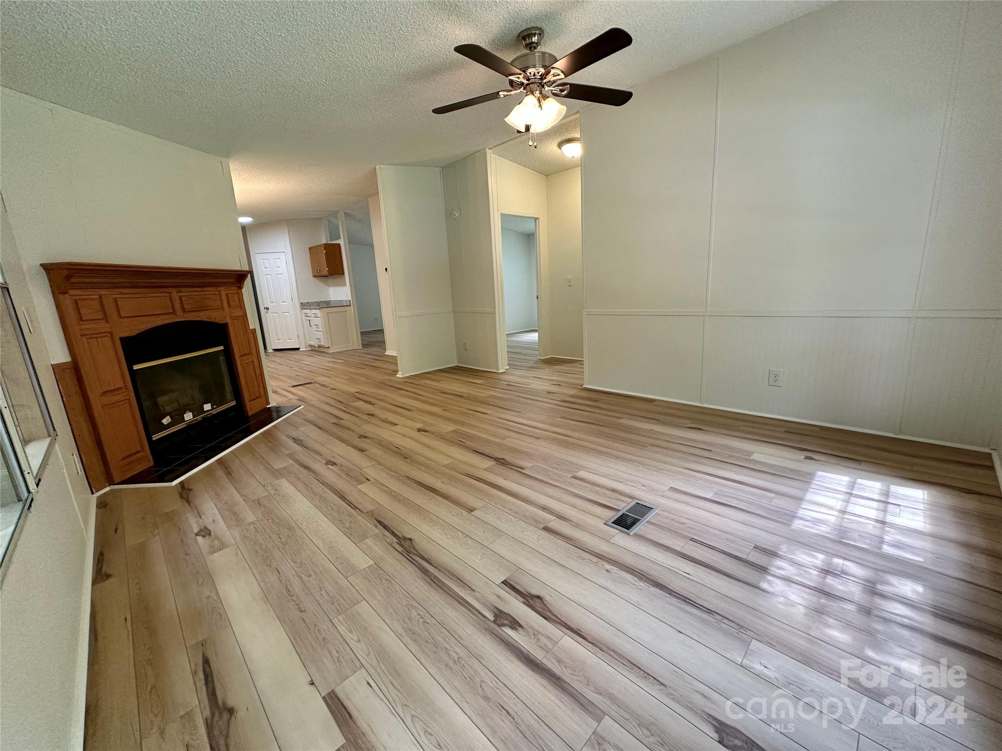 6686 Old Plank Road Stanley, NC 28164 - Photo 8 of 17 a view of empty room with fireplace and fan