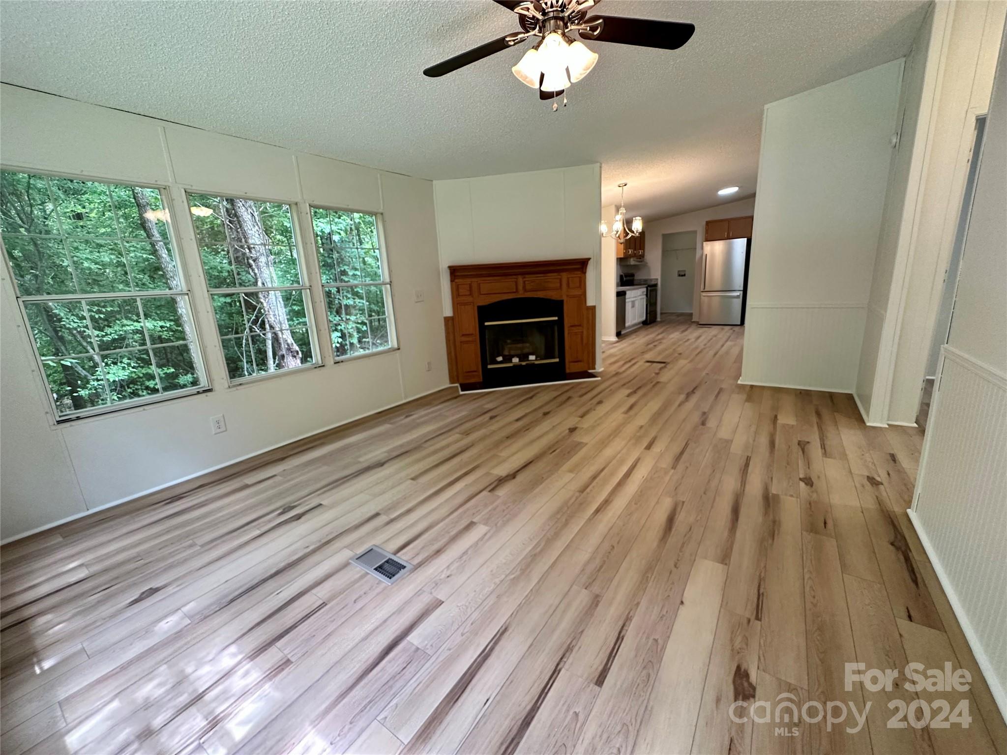6686 Old Plank Road Stanley, NC 28164 - Photo 9 of 17 a view of an empty room with wooden floor fireplace and a window