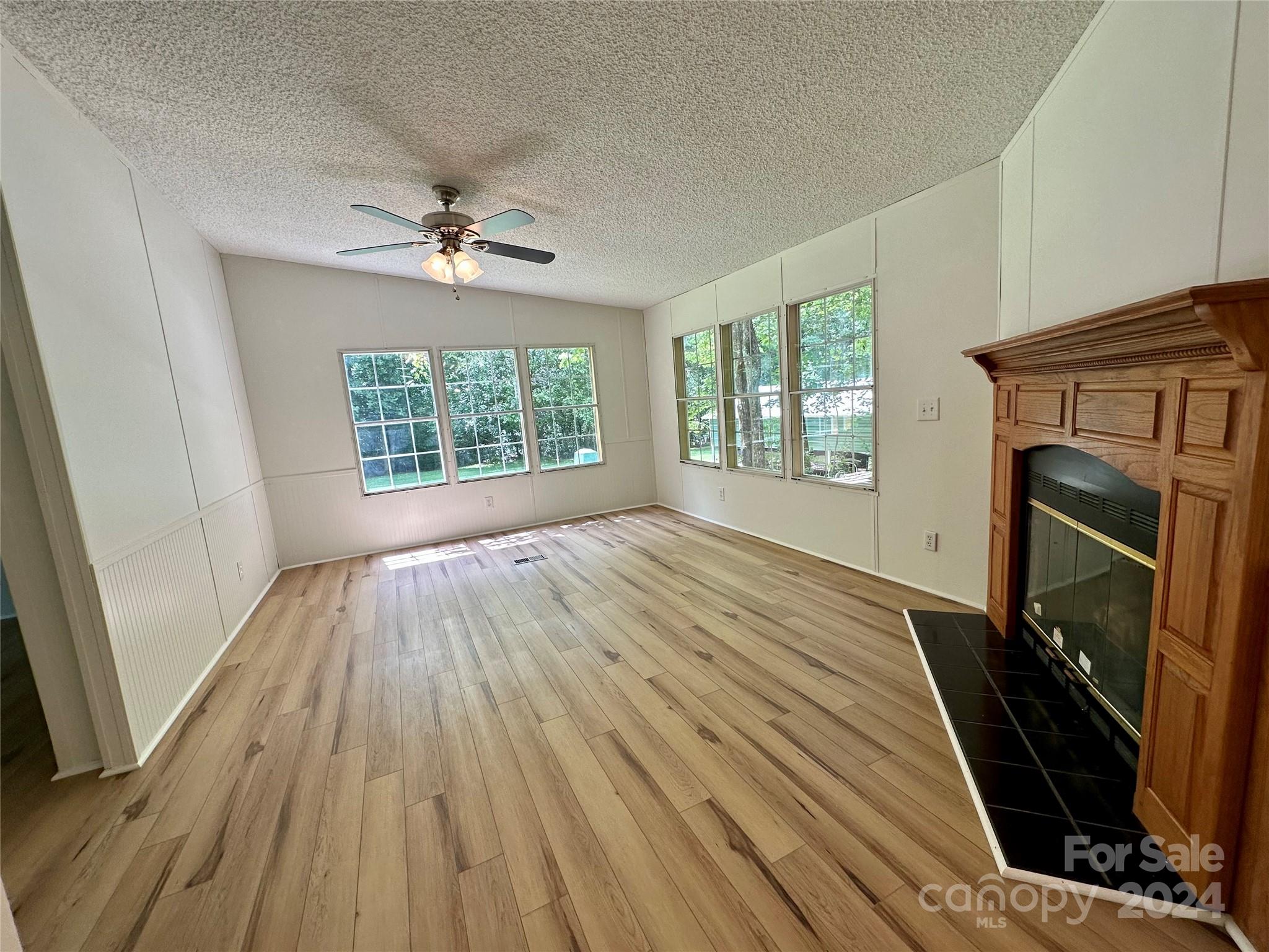 6686 Old Plank Road Stanley, NC 28164 - Photo 10 of 17 wooden floor in an empty room with a fireplace