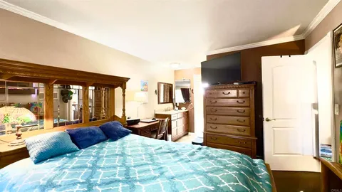 a bedroom with a bed and large windows