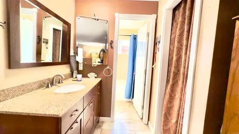 a bathroom with a granite countertop sink and a mirror