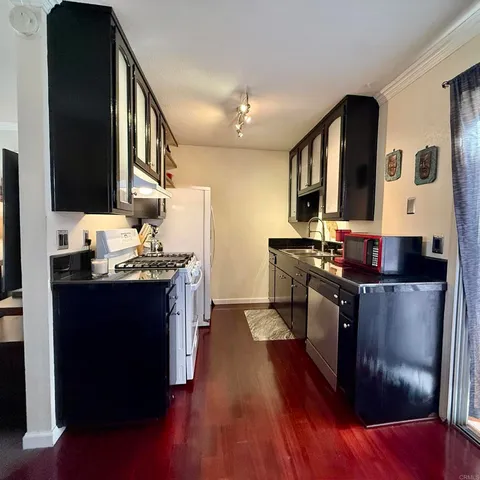 a kitchen with stainless steel appliances granite countertop a stove a sink and a microwave