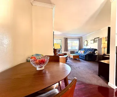 a living room with furniture kitchen view and a window