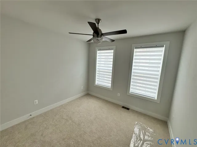 a view of room with a ceiling fan and window