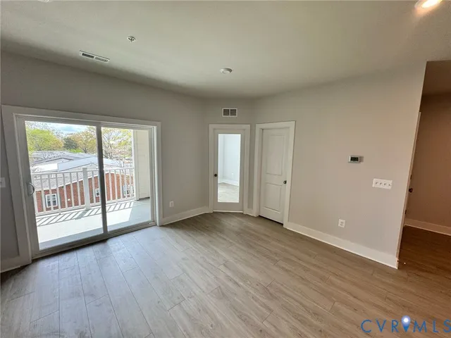 a large kitchen with stainless steel appliances a large counter top a stove a sink dishwasher and a refrigerator with wooden floor