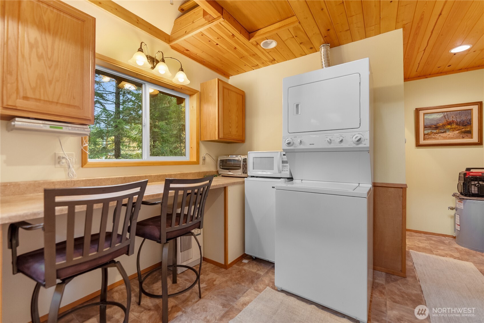 26 Mercer Road Mazama, WA 98833 - Photo 21 of 40 a kitchen with stainless steel appliances a table chairs and a refrigerator