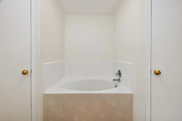 a white bath tub sitting next to a shower