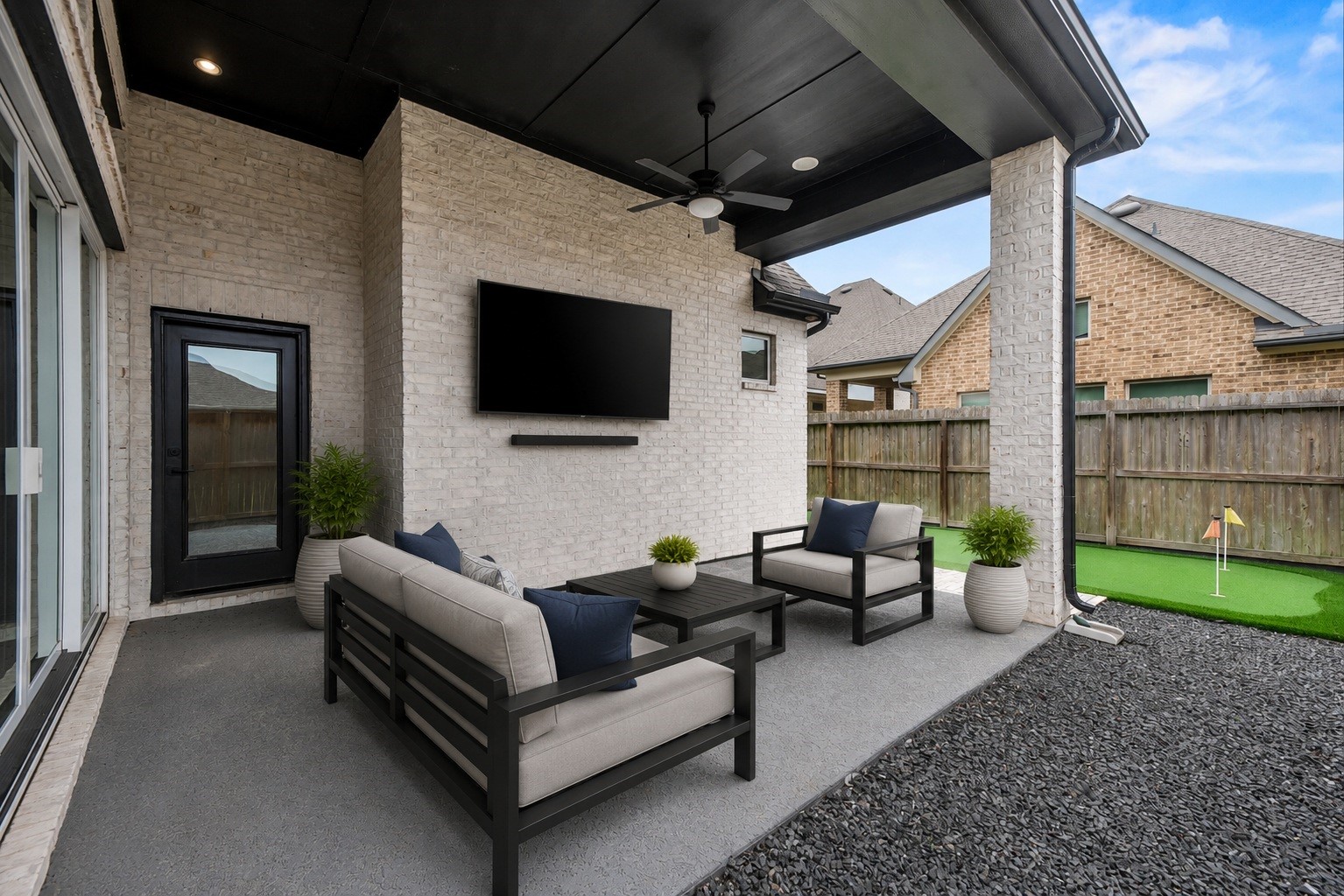 3438 Rich Radish Road Richmond, TX 77406 - Photo 18 of 25 Perfect for outdoor relaxation, the extended covered rear porch features a striking dark-stained ceiling accent, an integrated Kichler patio fan, a professional TV wall mount, and a dedicated gas line plumbed for your outdoor grill setup. Virtually staged.