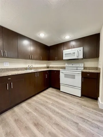 a kitchen with stainless steel appliances granite countertop a stove a sink dishwasher and a refrigerator