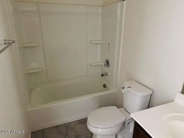 a white toilet and tub sitting next to a bathroom sink