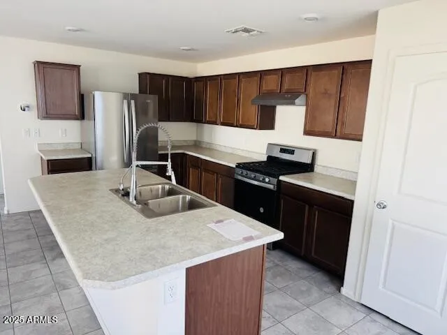 a kitchen with kitchen island granite countertop a sink stove and refrigerator