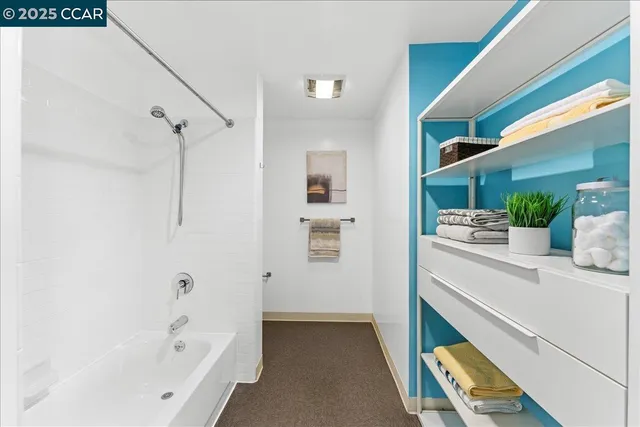 a white toilet sitting next to a white wall