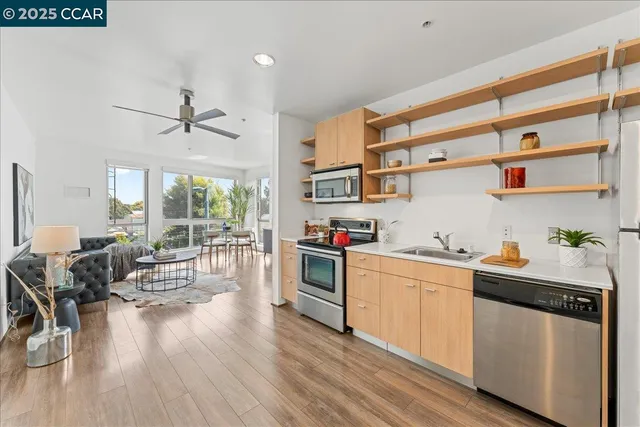 a kitchen with stainless steel appliances a stove a sink a cabinets and wooden floor