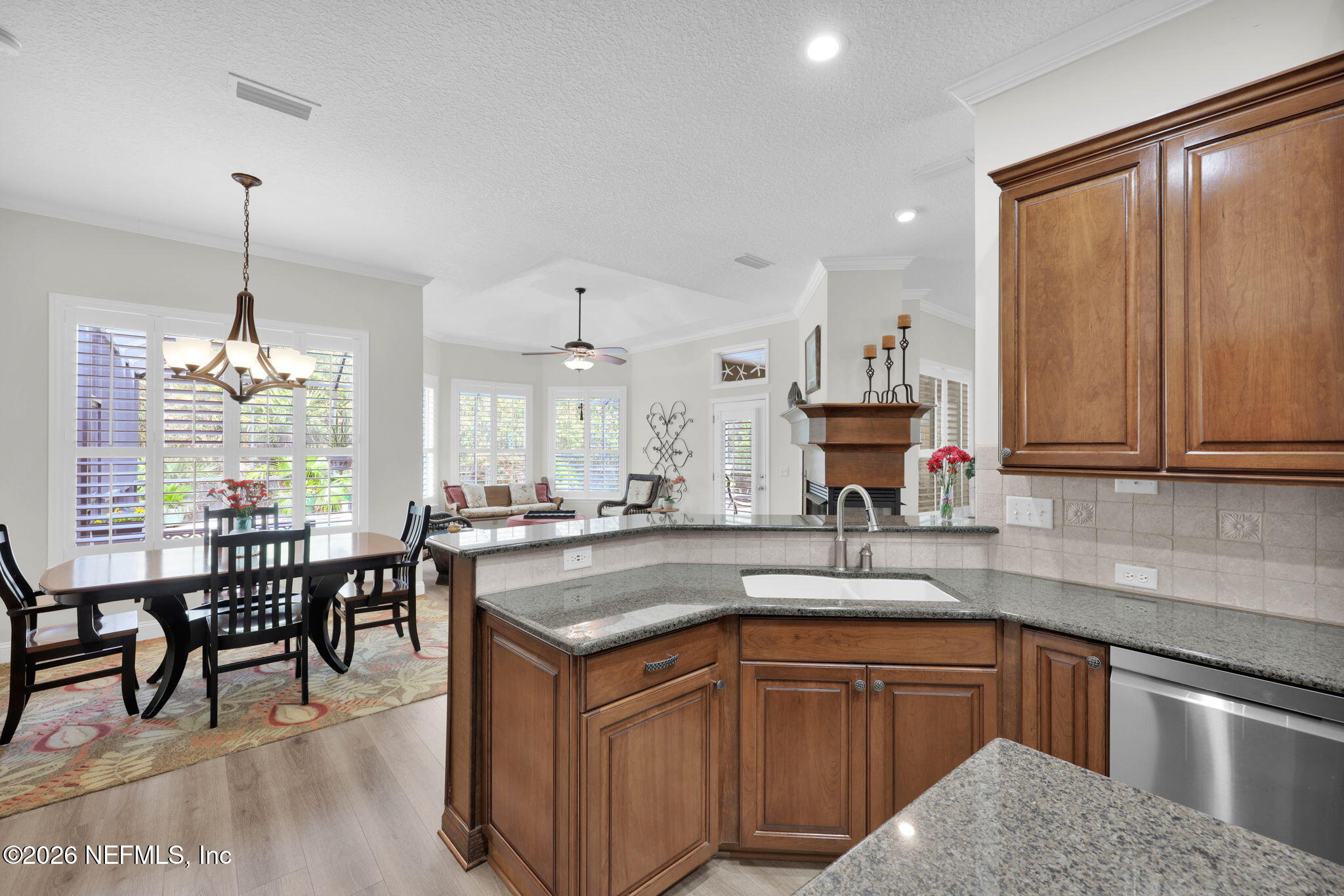 157 Oak Common Avenue St. Augustine, FL 32095 - Photo 17 of 57 a kitchen with stainless steel appliances granite countertop wooden cabinets a dining table and chairs