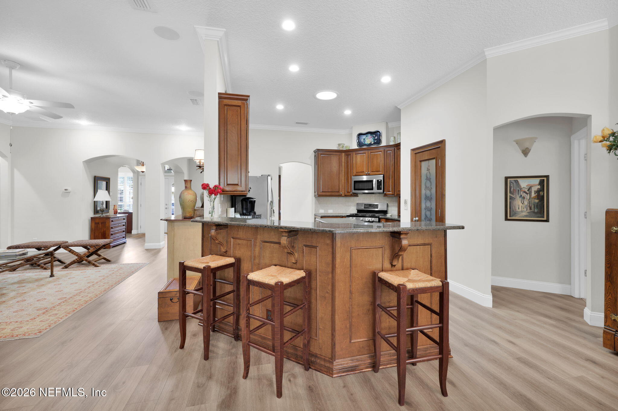 157 Oak Common Avenue St. Augustine, FL 32095 - Photo 18 of 57 a kitchen with stainless steel appliances kitchen island granite countertop a table chairs and a refrigerator