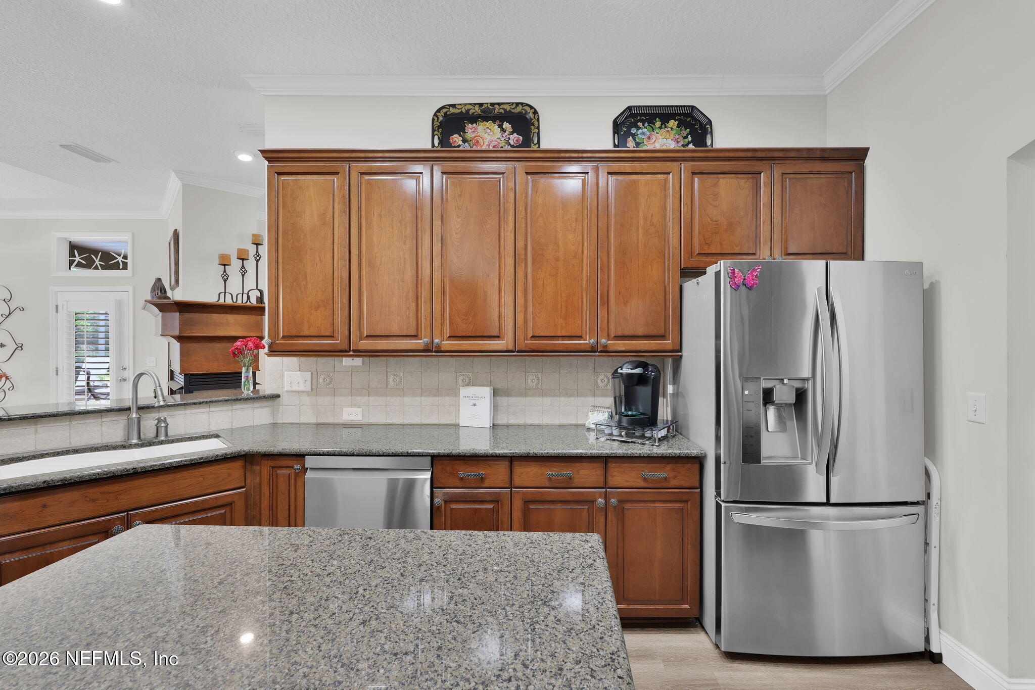 157 Oak Common Avenue St. Augustine, FL 32095 - Photo 19 of 57 a kitchen with stainless steel appliances granite countertop a refrigerator a stove and a sink with wooden cabinets