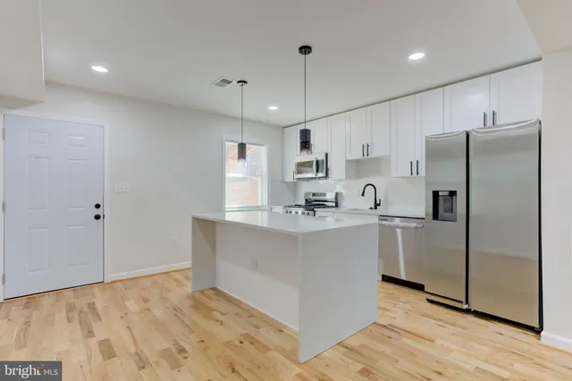 a view of kitchen with stainless steel appliances granite countertop refrigerator sink and microwave
