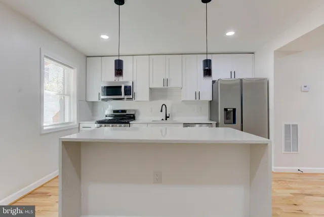 a utility room with a sink a wooden floor and a window