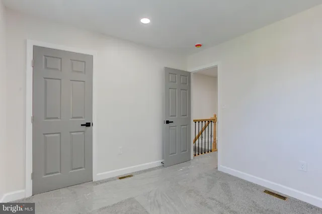 an empty room with windows and closet