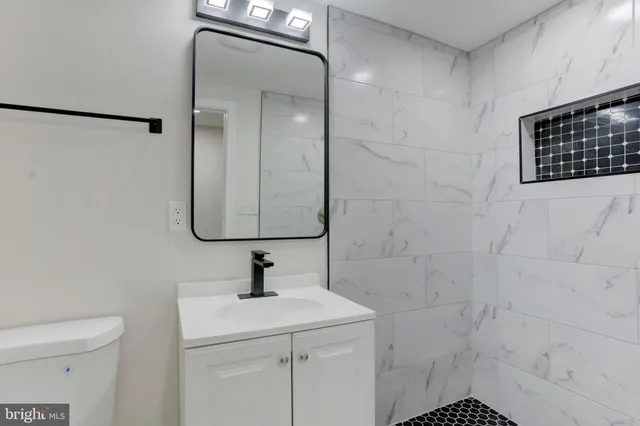 a bathroom with a shower sink and mirror