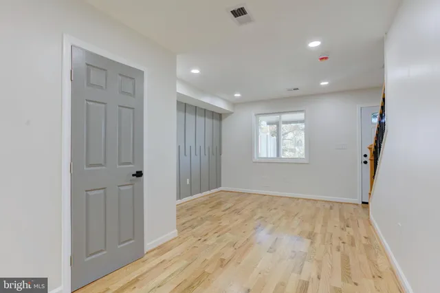 a view of empty room with wooden floor