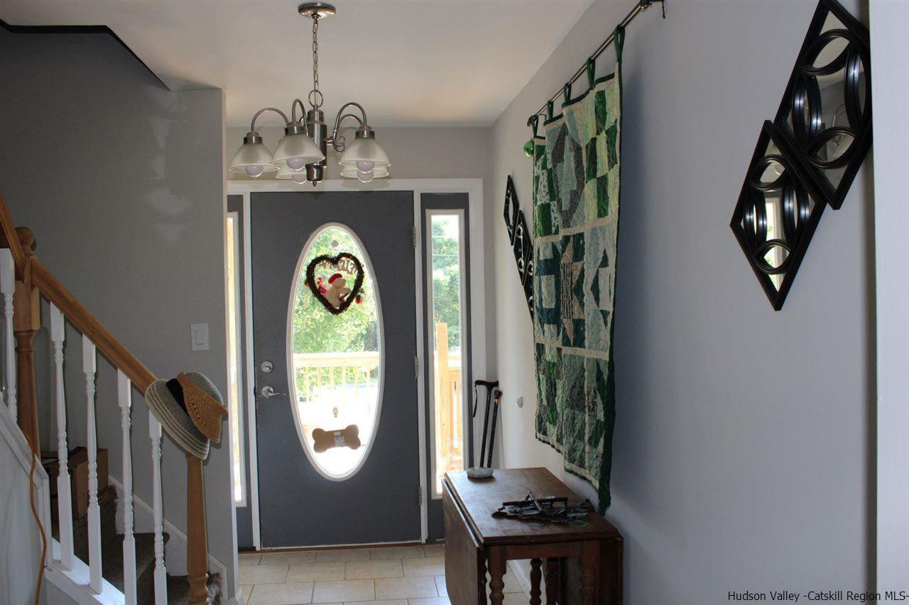 10 Iken Road Kerhonkson, NY 12446 - Photo 5 of 17 a view of a hallway with wooden floor and a chandelier