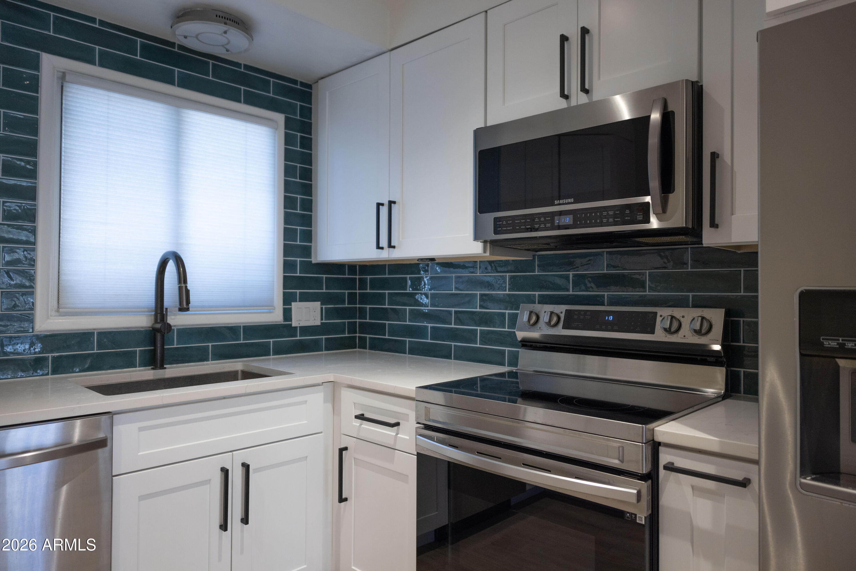 1450 East Bethany Home Road, Unit 31 Phoenix, AZ 85014 - Photo 3 of 24 a kitchen with a stove microwave and sink