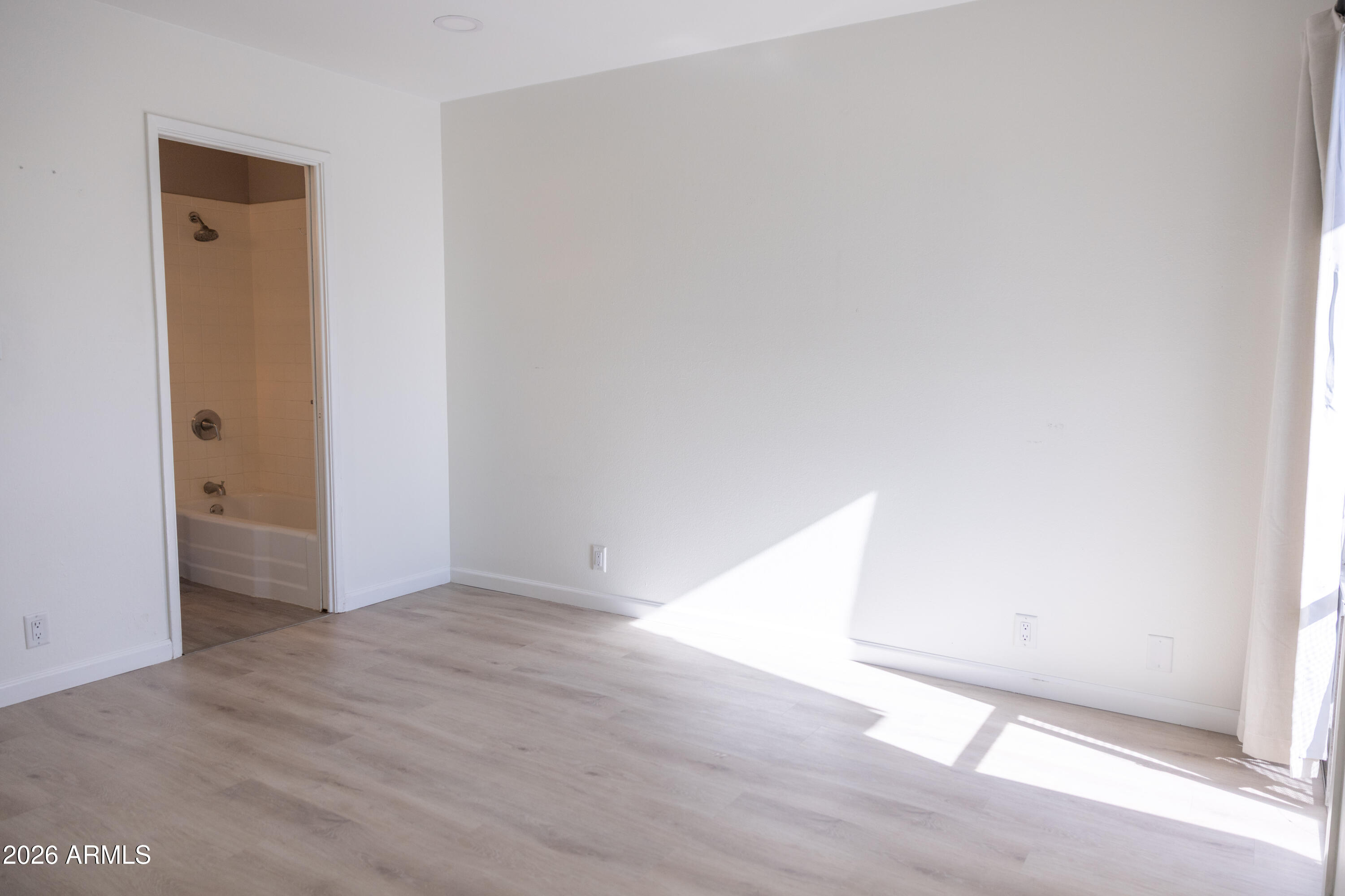 1450 East Bethany Home Road, Unit 31 Phoenix, AZ 85014 - Photo 9 of 24 an empty room with wooden floor and windows
