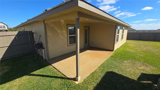 a backyard of a house with stainless steel appliances wooden floor and fence