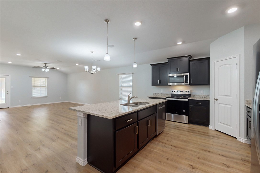2029 Rock Rdg Avenue Bryan, TX 77807 - Photo 7 of 31 a kitchen with stainless steel appliances granite countertop a sink a stove and a wooden floors