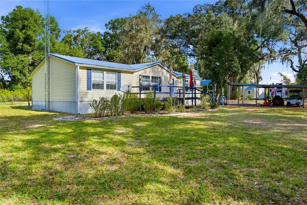a front view of house with yard and trees in the background